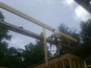 Carpenter setting a ridge beam over a new addition frame — Ice Dam Removal by Roofing Brothers in Tamaqua