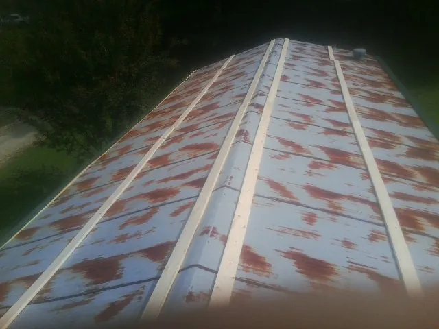 Rusted metal roof panels with new wood purlins before replacement — Storm Damage Roof Repair in Tamaqua by Roofing Brothers