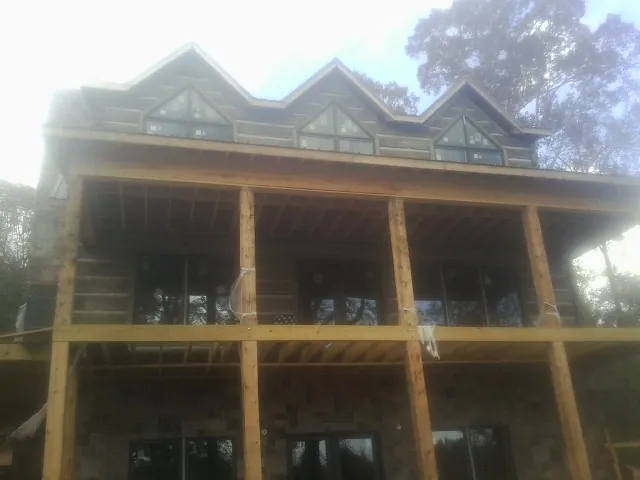 Dormers and porch framing on a large log home under construction — Roof Coating work by our crew in Tamaqua