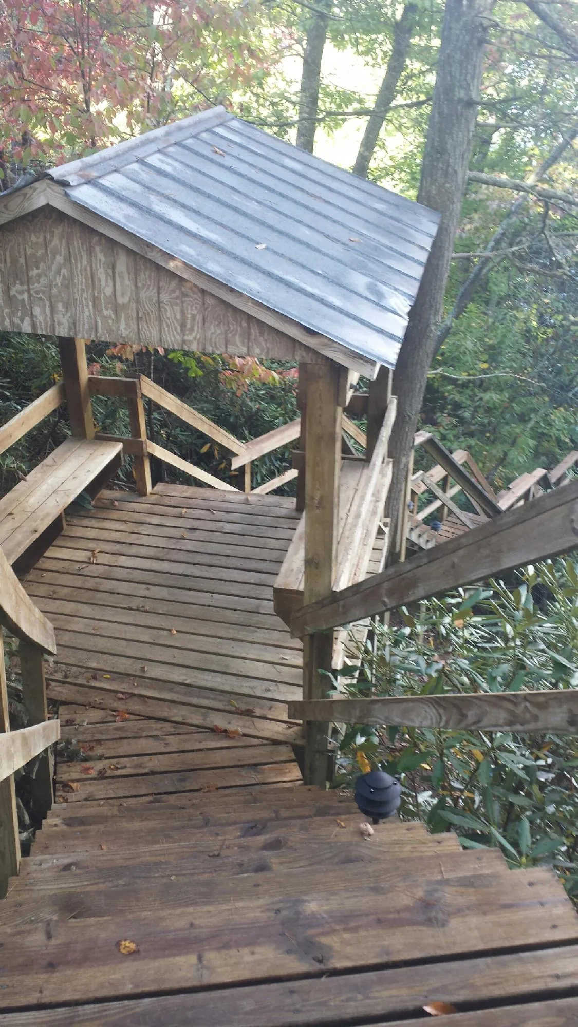 Metal roofed shelter over wooden steps on a wooded walkway — Skylight Repair & Installation work by our crew in Tamaqua