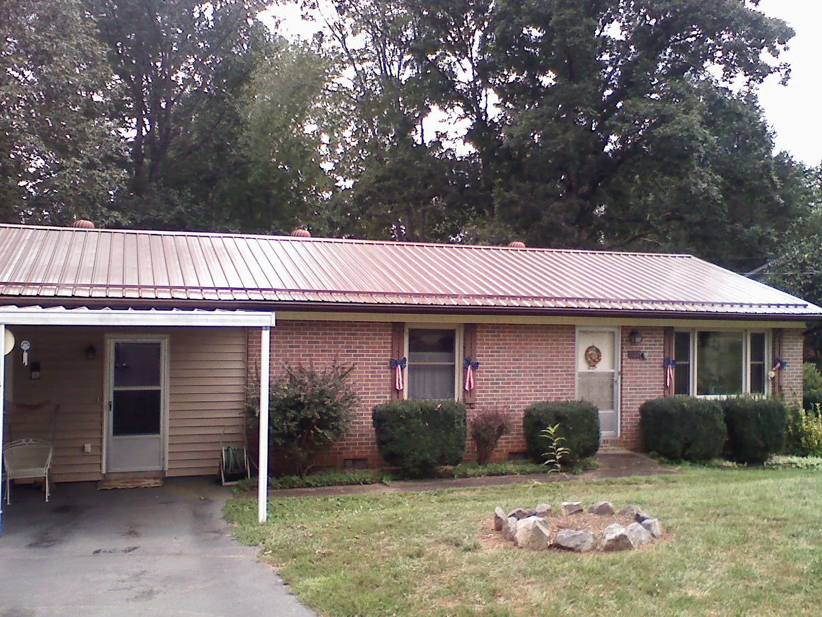 Bronze metal roof and carport on a brick ranch home — Roof Repair work by our crew in Tamaqua